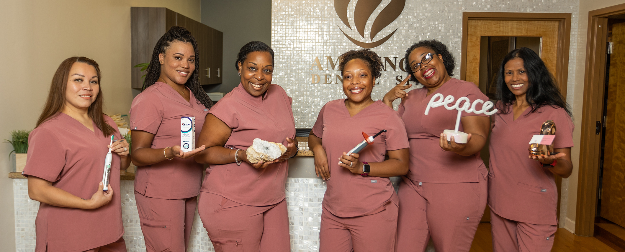 Each of the Bowie dental team members at Ambiance Dental Spa holding a different dental object