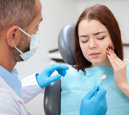 A young woman seeing her dentist for help with her toothache