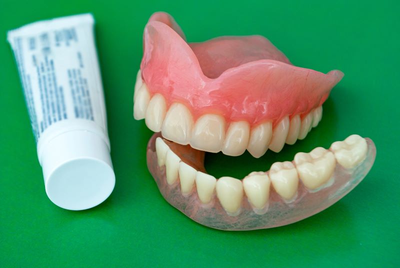 person using denture adhesive