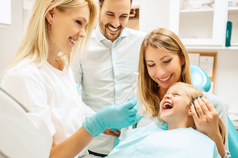 A family supporting their daughter as she receives dental care